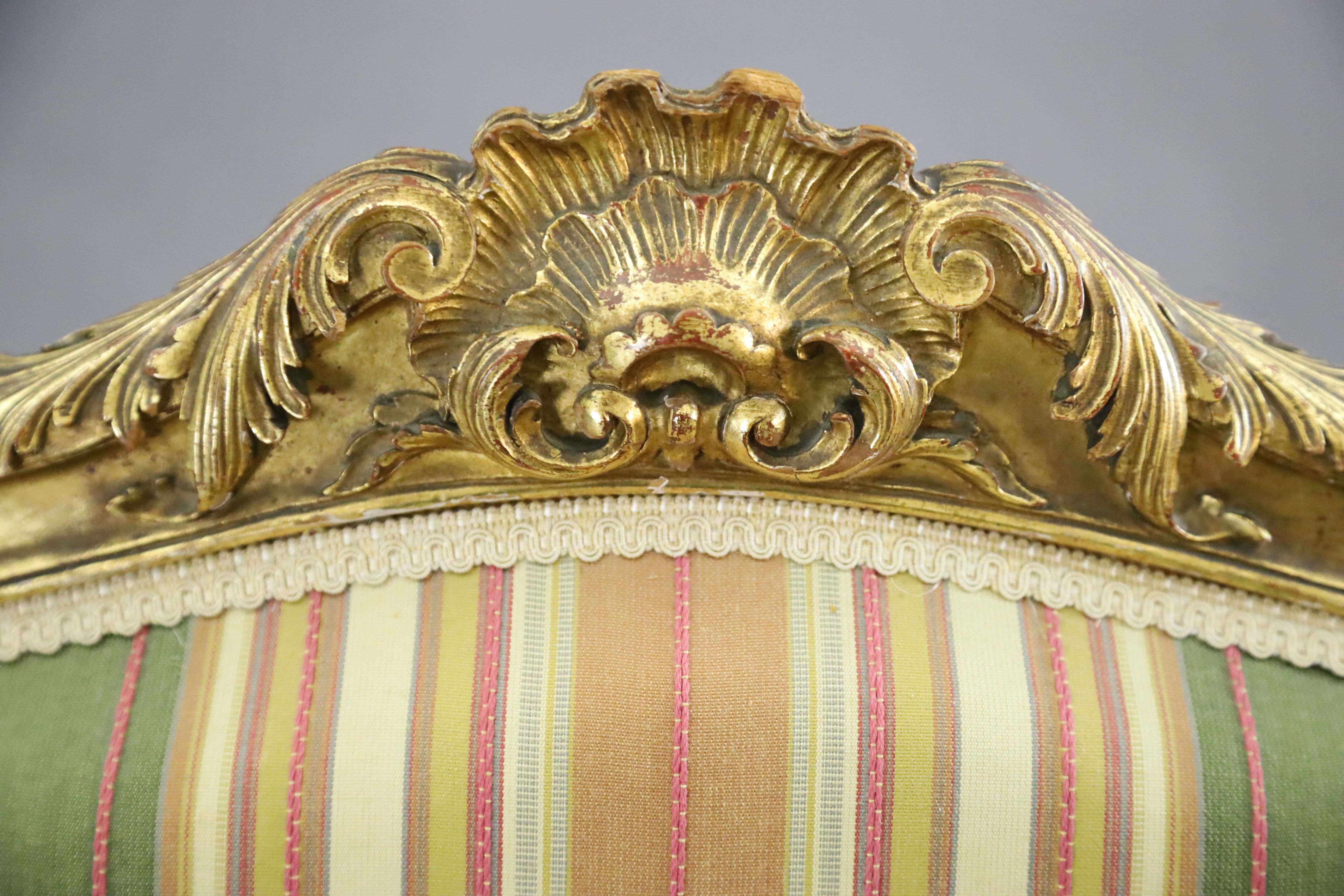 A pair of French gilt beech fauteuils, W.2ft 3in. D.2ft 1in. H.3ft 5in.